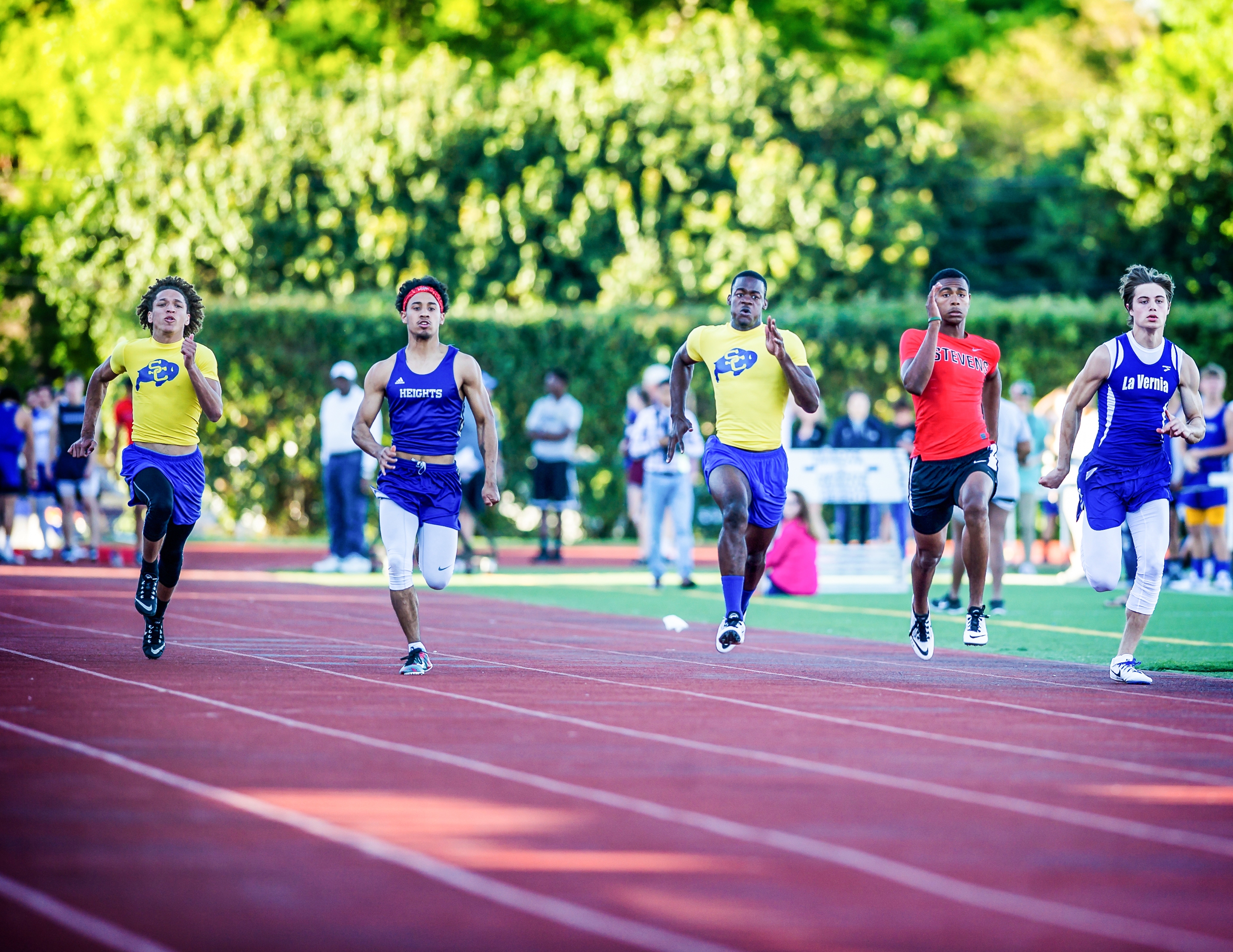 Clemens junior Luke Kelley (center) runs the 100 meter dash clocked 10.93c at the Alamo Heights Mule Relays.