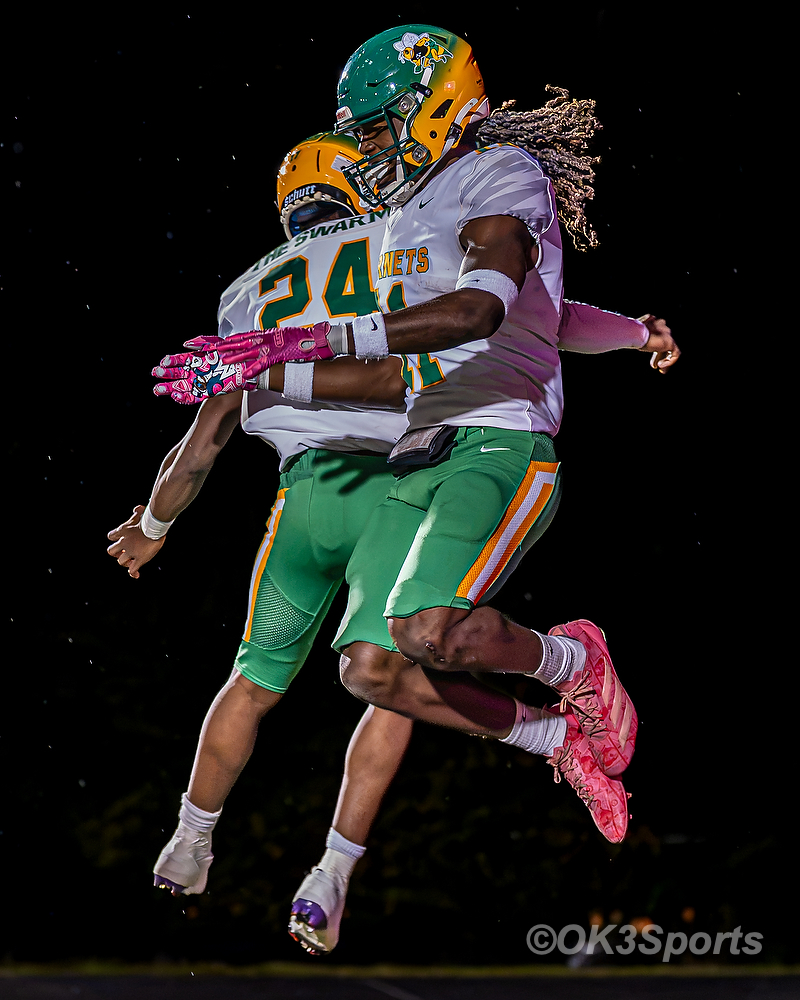 C.A. Johnson players Johnathon Jenkins and #24 celebrate with a midair chest bump