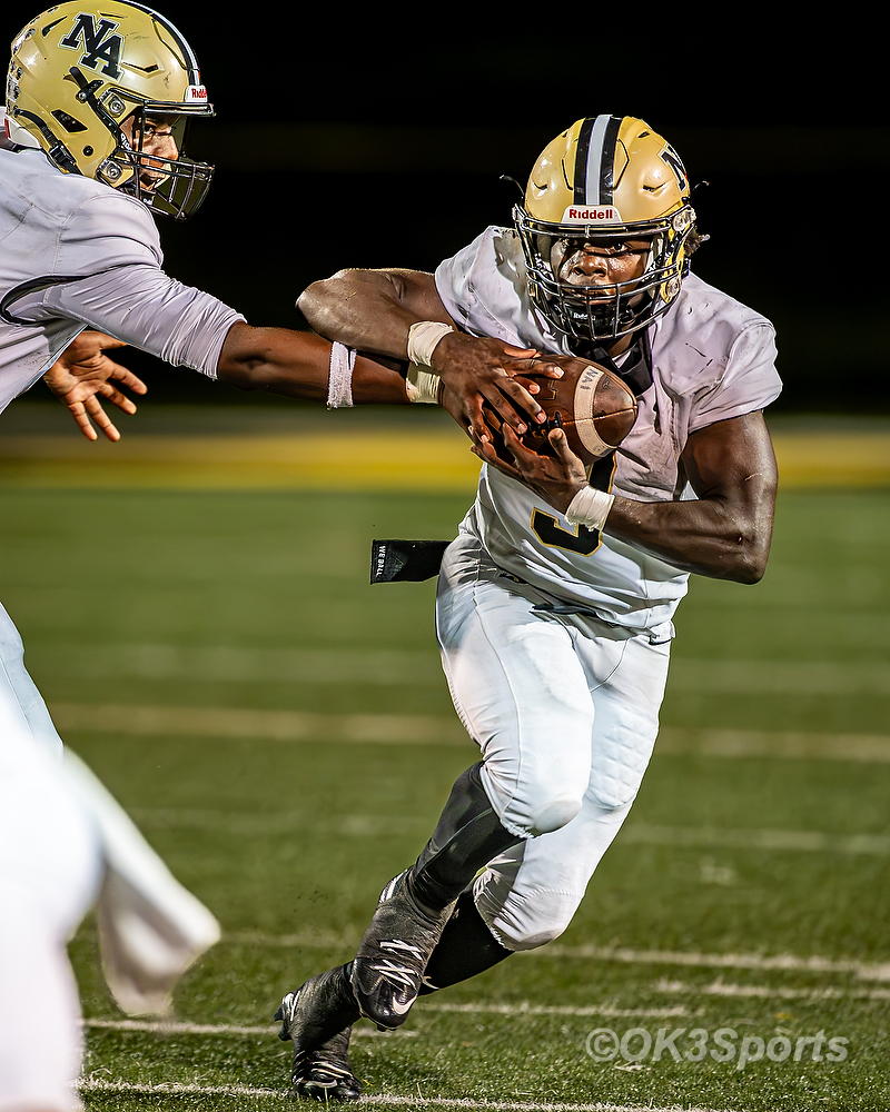 Running back #3 takes a handoff and heads for the hole