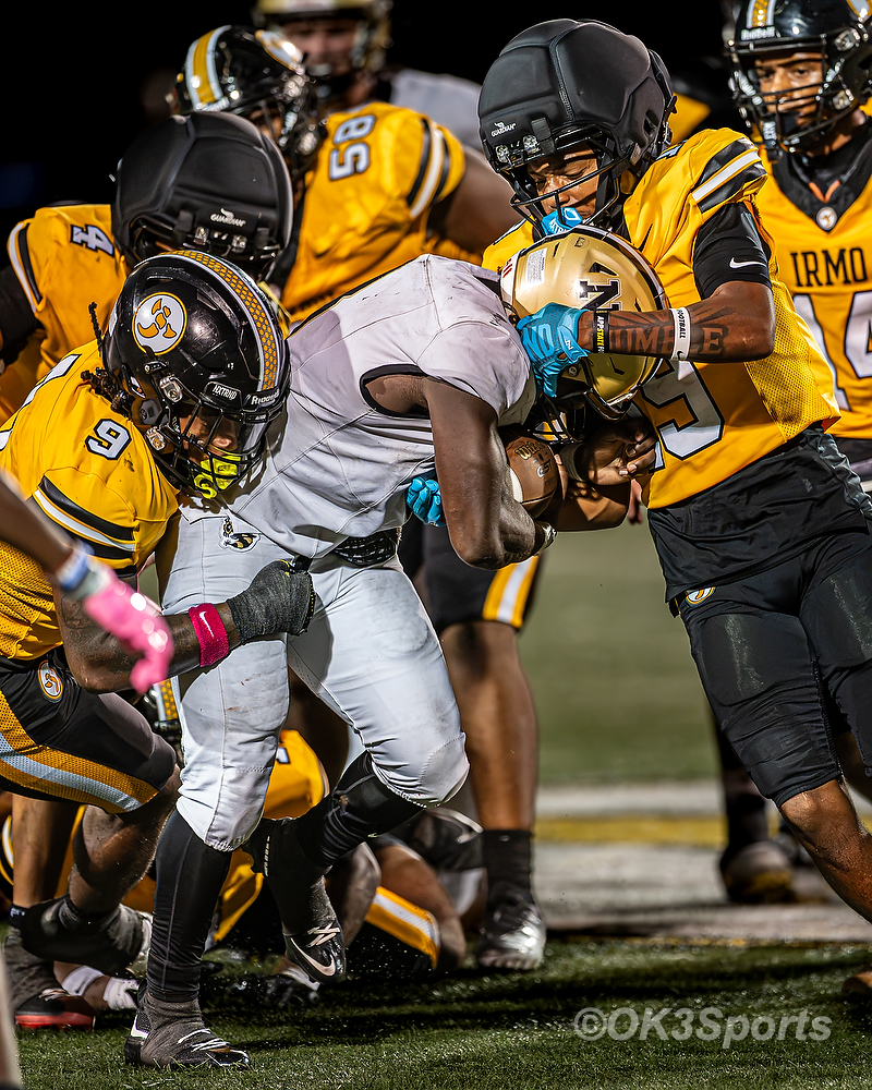 Running back #3 fights for extra yards through a crowd of defenders