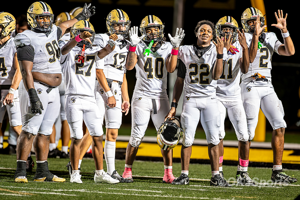 Players celebrate at midfield after the game on a Friday night